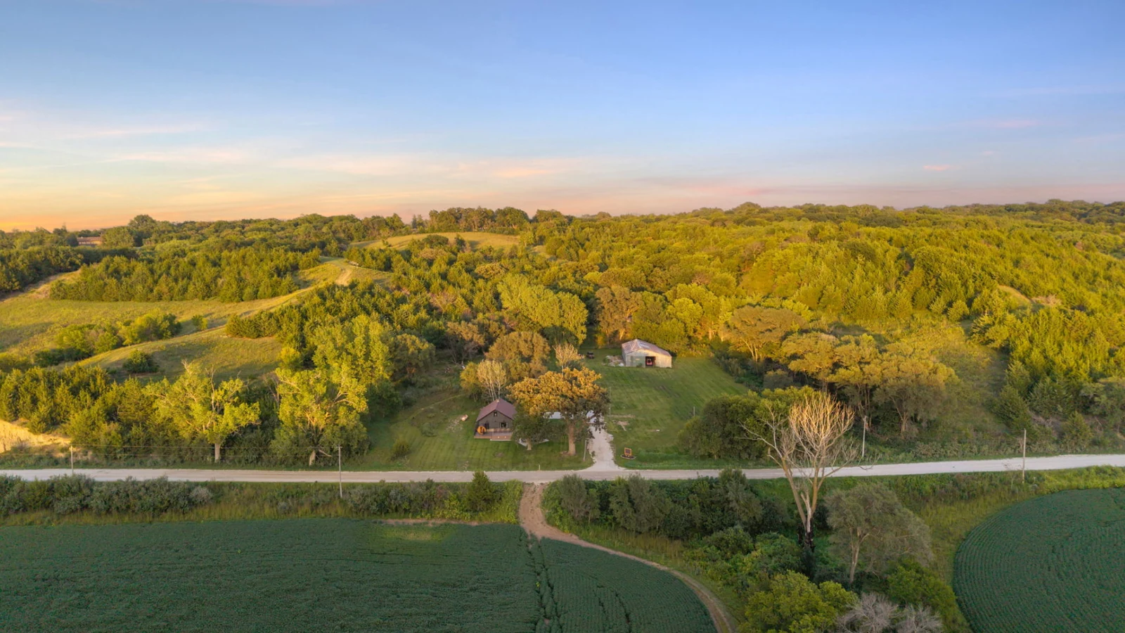 Aerial sunset view of Loess Lakes Ranch surrounded by the rolling wooded Loess Hills
