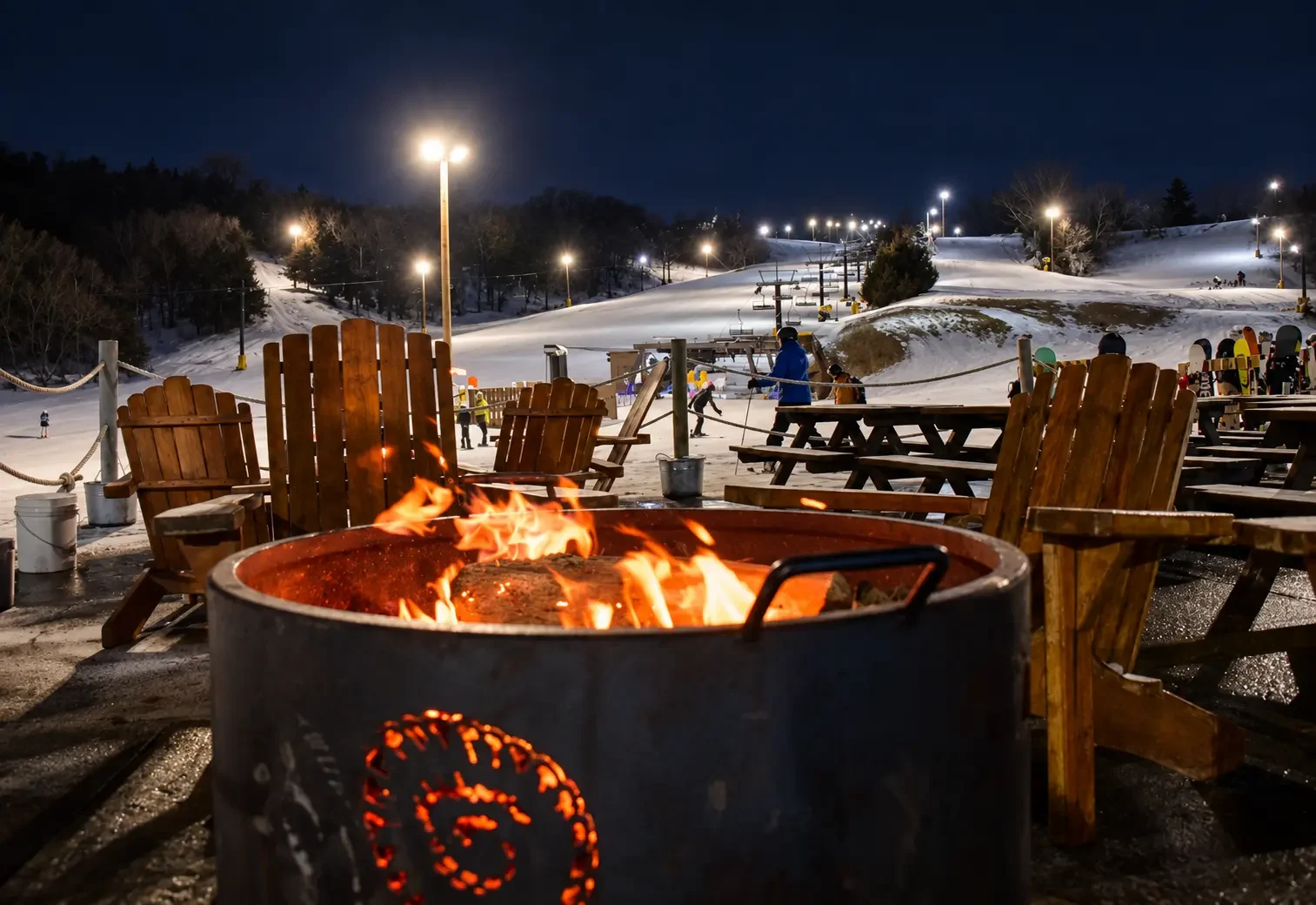Night skiing under the lights at Crescent Hill at Hitchcock, with a round fire bowl in the foreground