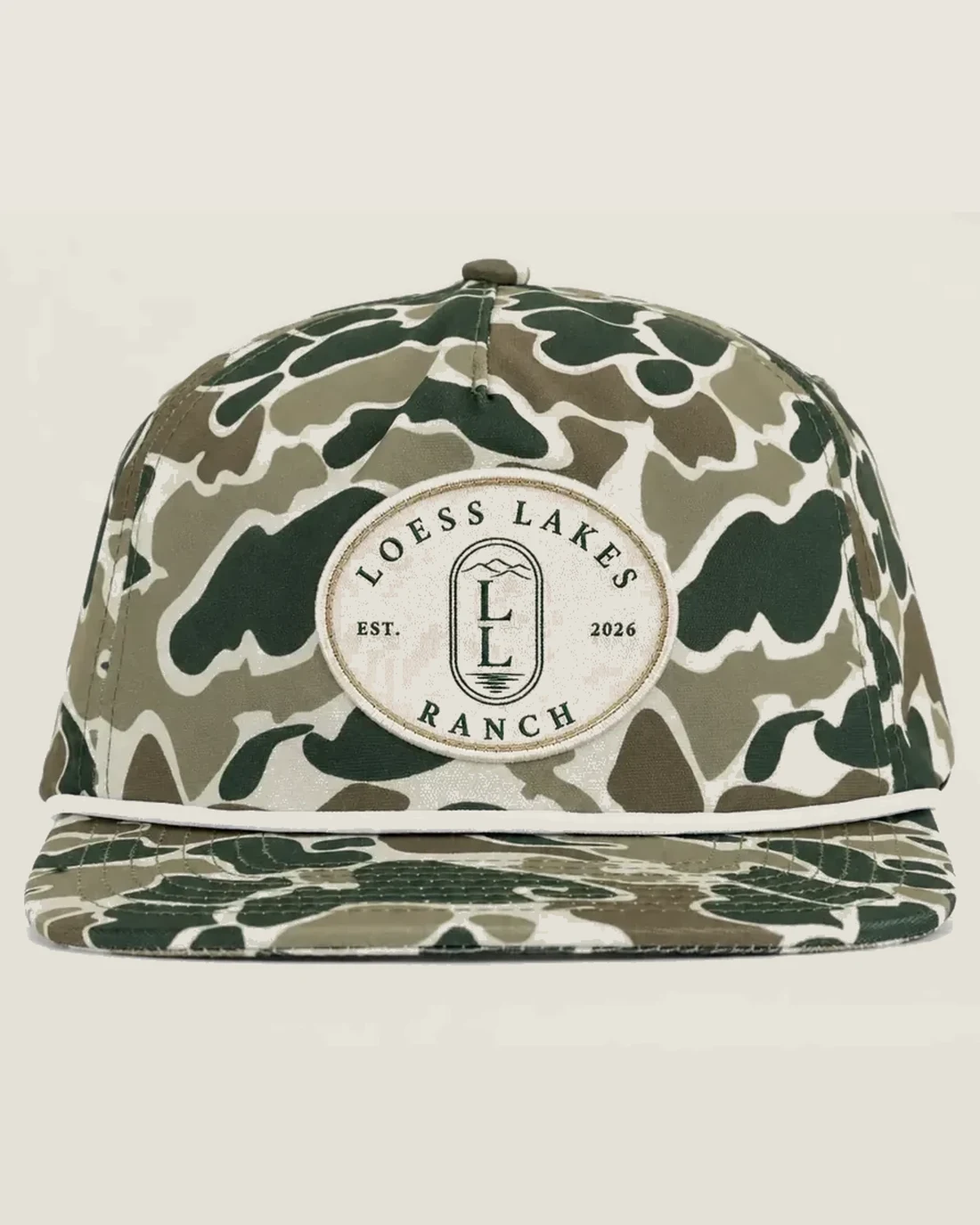 Field-camo rope cap with an oval woven LOESS LAKES RANCH EST. 2026 patch and cream rope