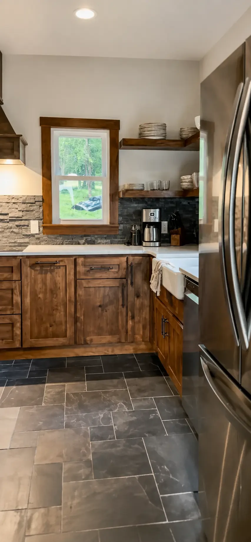 Ranch kitchen with open walnut shelves, stone backsplash and stainless refrigerator