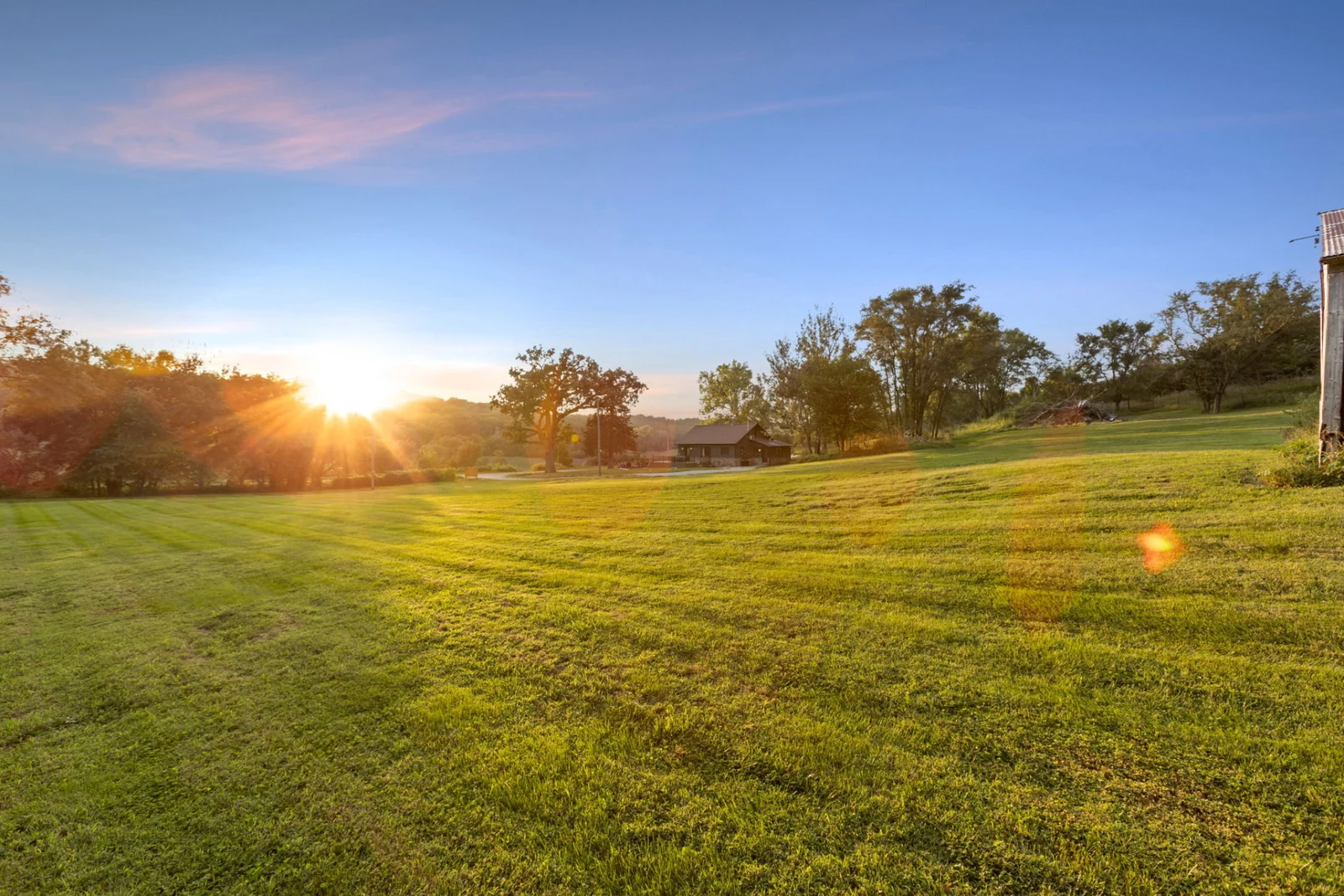 Golden evening light crossing the expansive lawn at Loess Lakes Ranch