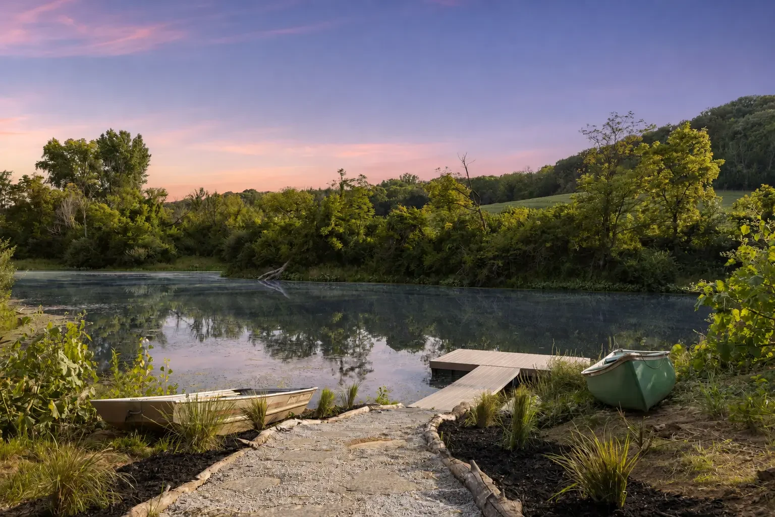 Stone path leading to a lakeside dock and two boats beneath a pastel evening sky