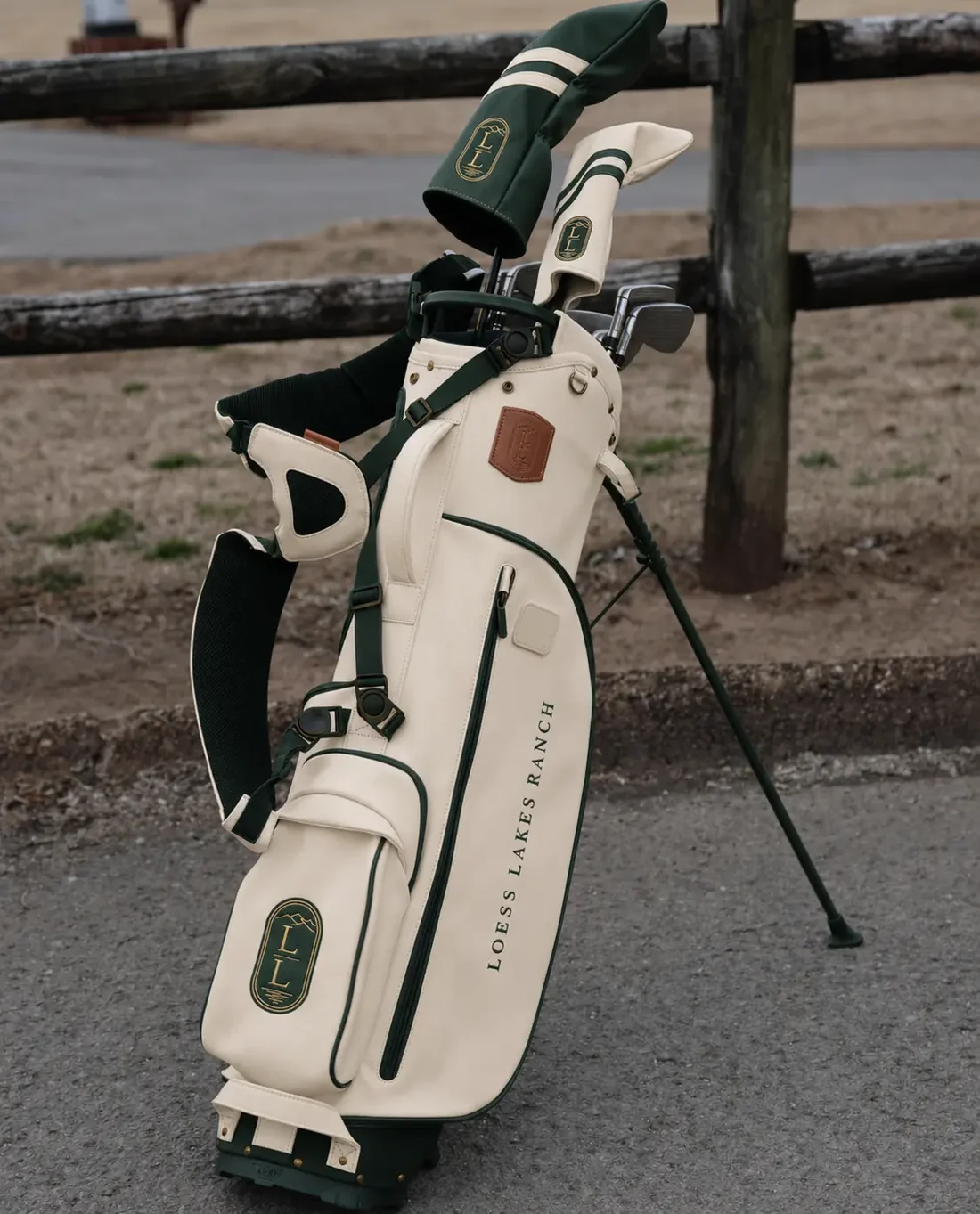 Cream LOESS LAKES RANCH stand bag with deep-green trim, leather-look tag and two branded headcovers